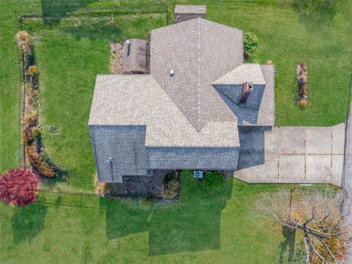 A direct overhead shot of the house, focusing on the roof structure. This gives potential buyers a clear view of the roof's layout and condition, as well as the positioning of the driveway and entrance.