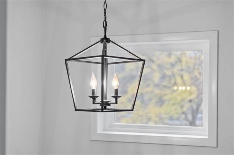 Pause at the top of the stairs to admire the design of the light fixture and outside vista framed by second story window beyond.