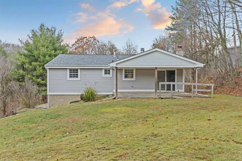 Back of home with covered patio deck.