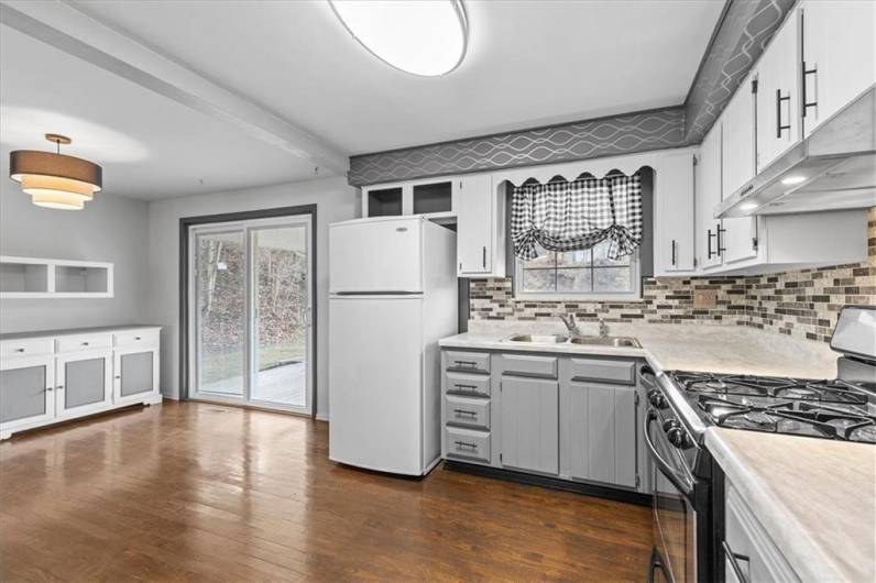 Spacious eat in kitchen with hardwood floors.