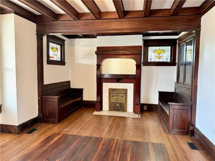 The living room has the old world details that make this a truly custom space from the stained glass to the benches, fireplace and built ins.