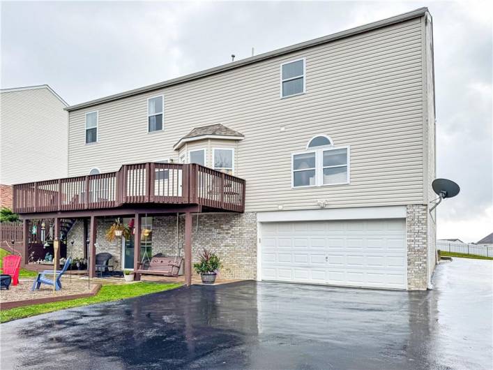 Newer asphalt driveway leads to the deep two car garage.