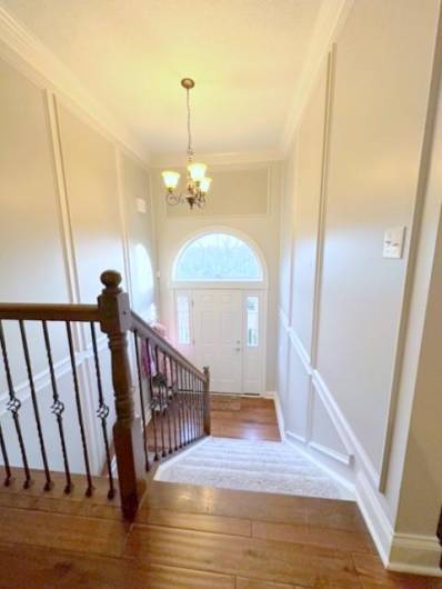 The Foyer is 13'x7' with elegant picture box molding and double crown molding at the ceiling lines. The elegant wrought-iron basket spindles are topped with solid oak newels and handrails.