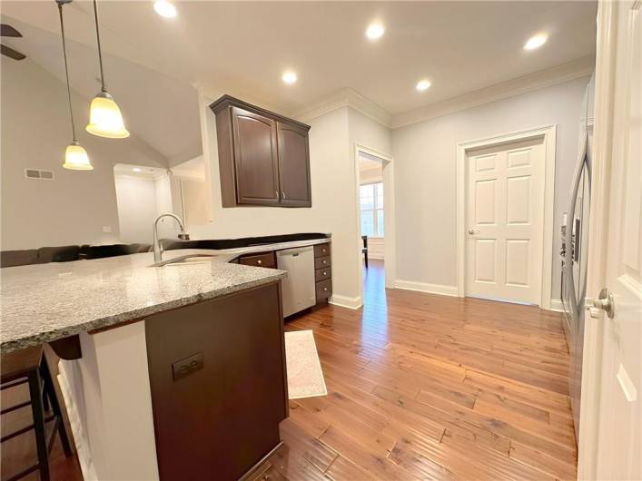 This is the sink area with lots of cherry cabinetry with soft close drawers enhanced with solid oak flooring, looking towatds the Family Room.