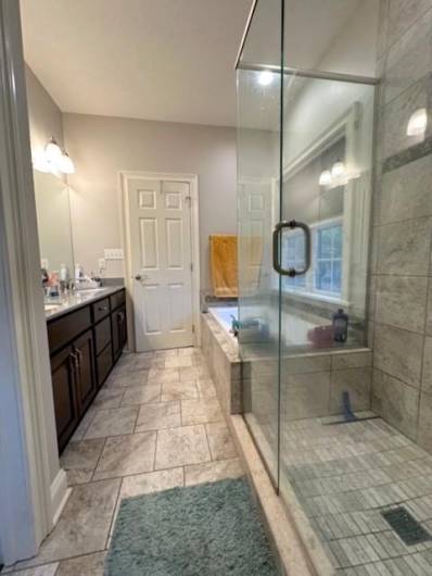 The Master Bath has ceramic tile floor and a floor to ceiling ceramic shower and a soaking tub with a ceramic base.