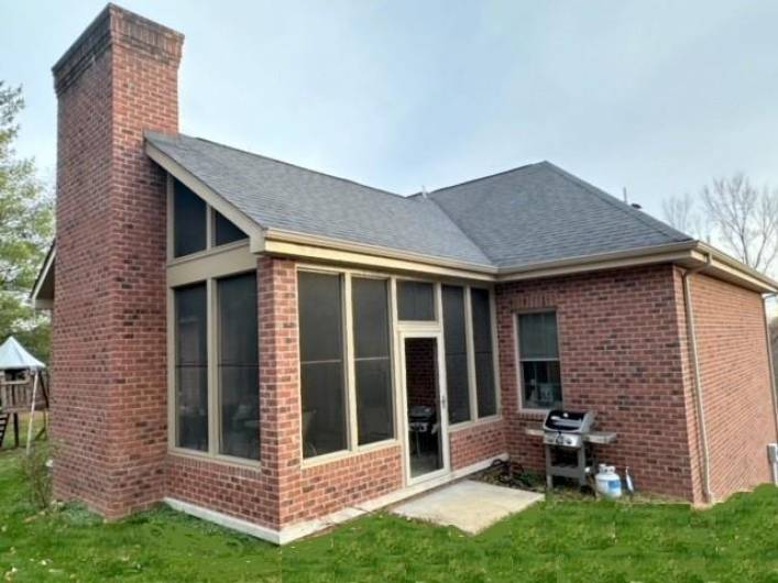 This view shows the totally enclosed three season patio room which is 23'x14.5' with a floor to ceiling fireplace, The roof on the Patio is a Dormer roof.