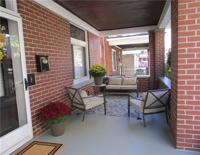 Large, covered front porch with beautiful vintage wooden ceiling and gorgeous transom windows.