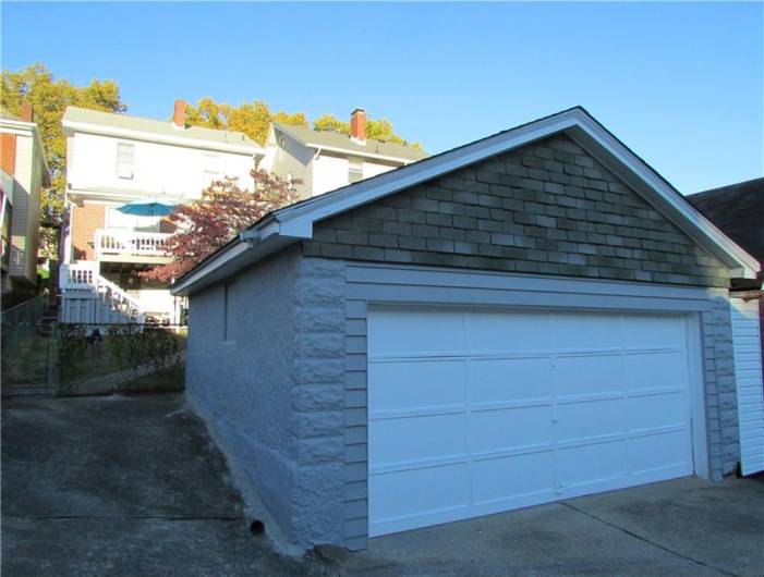 Large 2-car detached garage with parking pad to left.