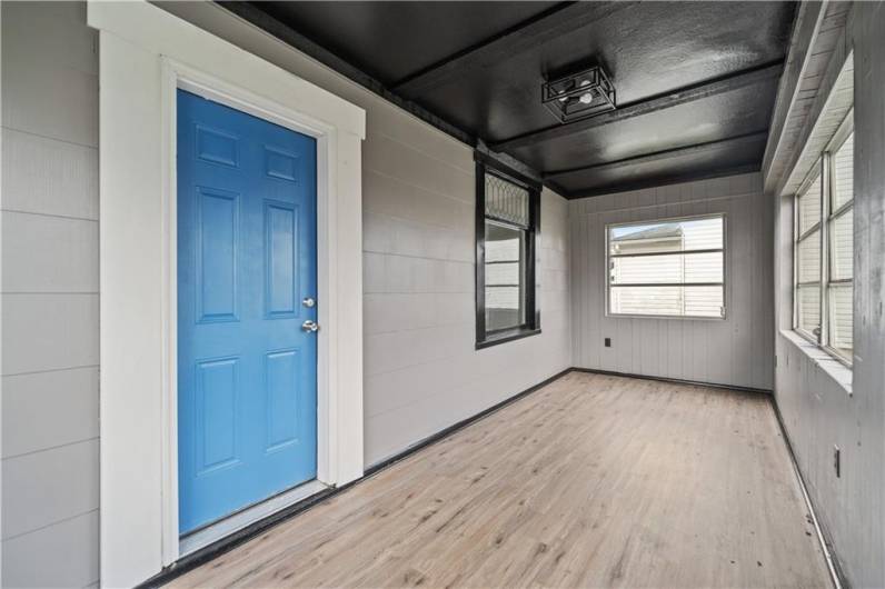 Enter into the enclosed sunporch with an abundance of light. Room for a comfy chair or add benches for a perfect mudroom.