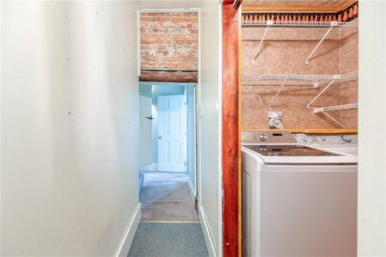 Hallway leading to the laundry room on right and 2nd full bath also on the right.