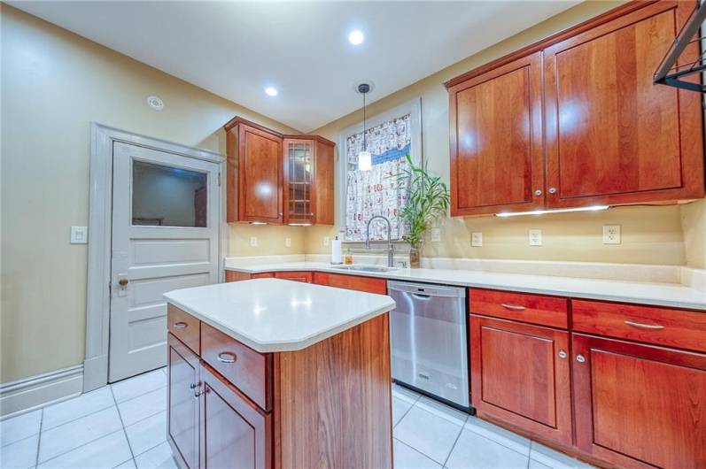 RECESSED LIGHTING AND A BEAUTIFUL FLOOR ACCENT THE BRIGHT KITCHEN.