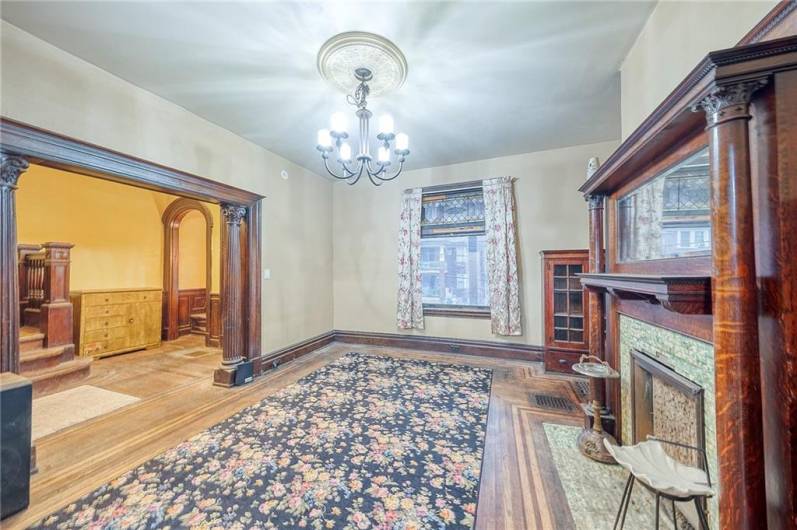 VINTAGE TOUCHES THROUGHOUT THE SPACIOUS LIVINGROOM; DECORATIVE FIREPLACE, BUILT INS, STUNNING WOODWORK, HARDWOOD FLOORS, LEADED GLASS TRANSOM.