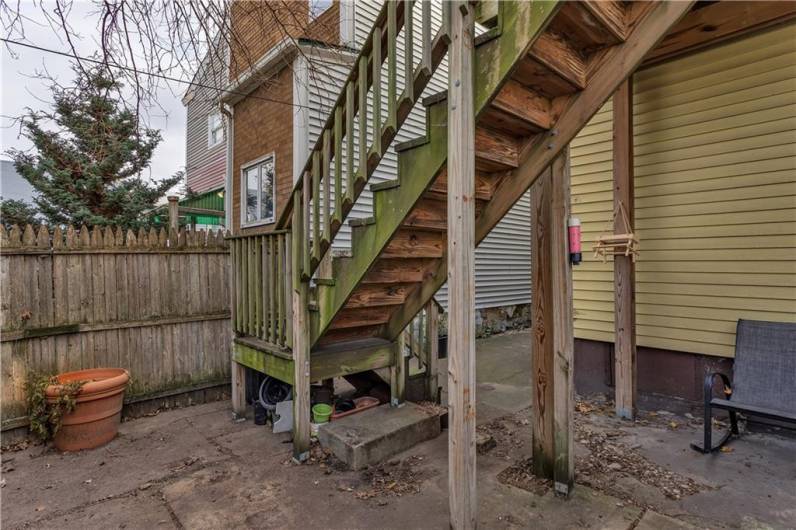 Steps from Upper Level Deck Lead to Lower Patio and Walkway to the Front of the Home.