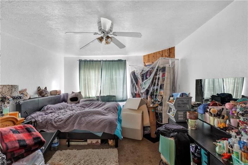 First Floor Unit Bedroom with Ceiling Fan. Front Facing Window.