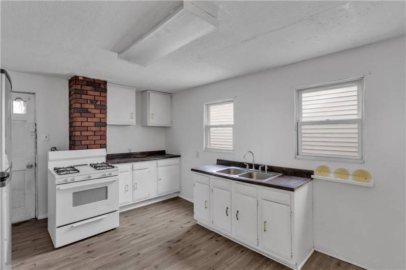 Two Windows Flank the Double Stainless Sink and Door Opens to Rear Deck.