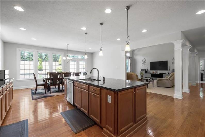 The open concept Kitchen boats Granite Counters, Tile Backsplash, Huge Island, Stainless Steel Appliances, & a Walk-in Pantry.