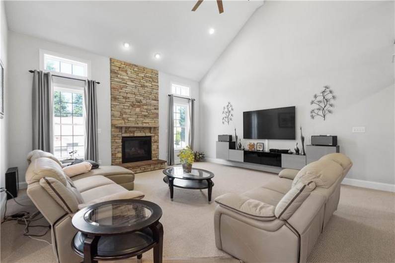 The Great Room is cozy with a stone fireplace and a 2-stroy vaulted ceiling.