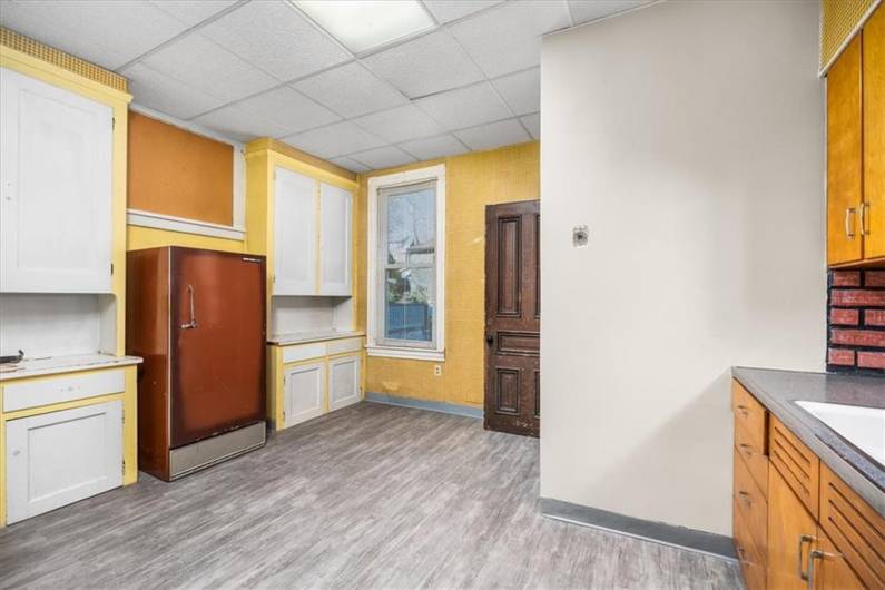 Large kitchen area with refrigerator and door to enslocsed back porch.