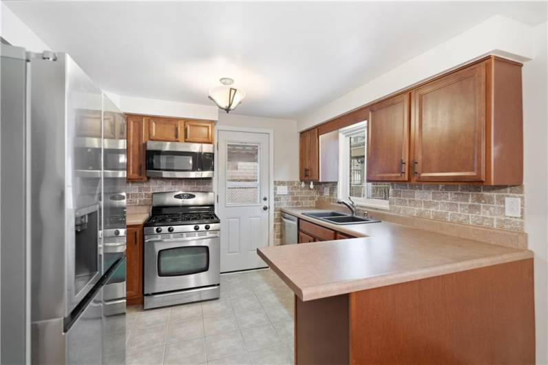 Updated stainless steel appliances and wood cabinets bring warmth to this kitchen.  Step right outside to your covered patio to grill or relax!