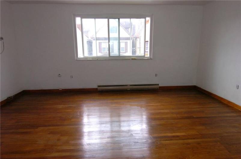 Living room in Apt. 4 showing front window and refinished floor.