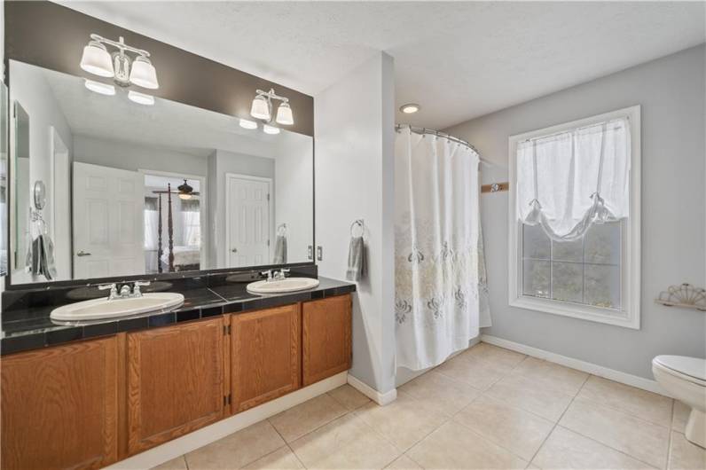 The primary bathroom features tiled floor and double bowl sinks.