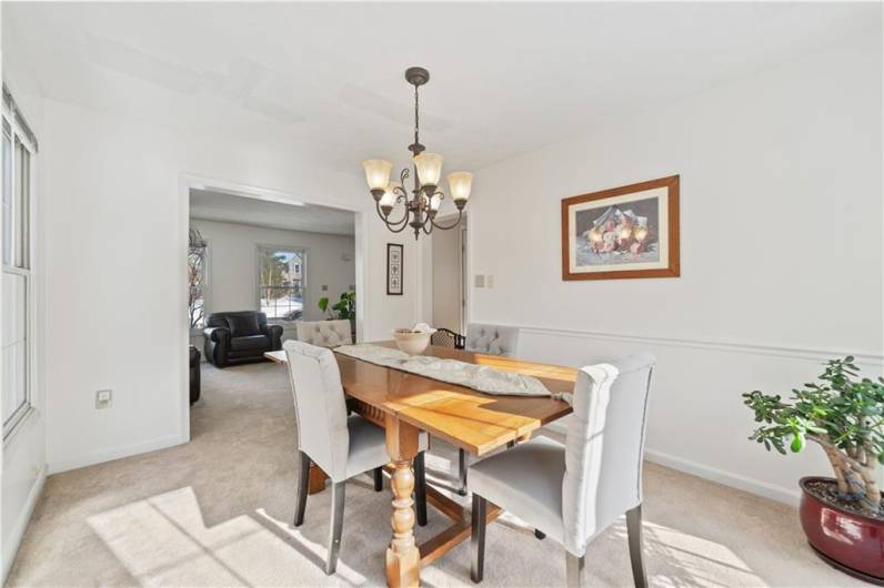 The dining room is adjacent to the living room and kitchen.