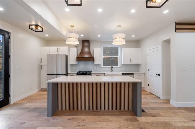 The 8 foot quartz kitchen island is simply a masterpiece.   Fit 4 counter stools across and your friends and family can cozy up and chat while you cook.  They'll never be underfoot with so much space and a conversational layout.