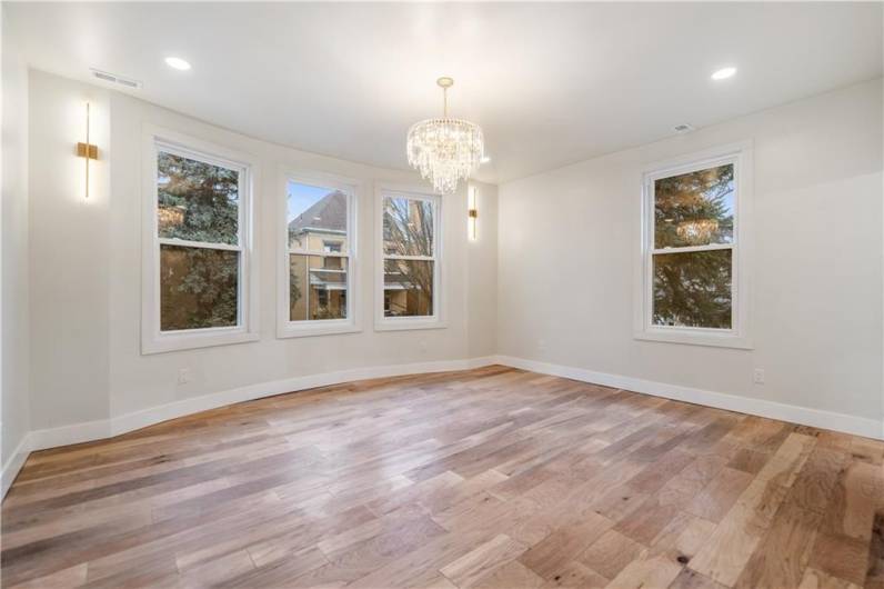 The primary bedroom is an absolute show stopper!!!! Look at that gently curving wall of windows!  Cozy up in your king bed and have sweet dreams in this room!