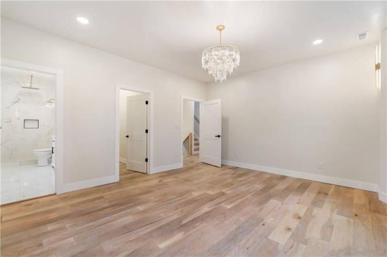 The primary bedroom is an absolute show stopper!!!! Look at that gently curving wall of windows!  Cozy up in your king bed and have sweet dreams in this room!