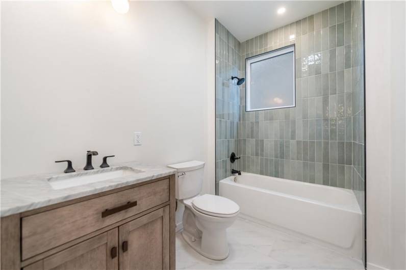 The main full bath on the second floor has luxurious waterlook tiles from tub to ceiling.   Dramatic! You'll feel like you are in a spa getaway every day!