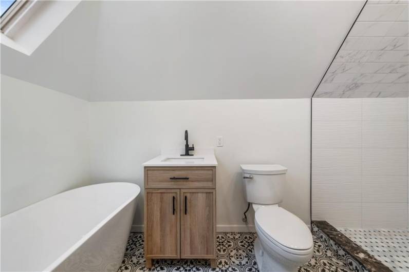 Black and white porcelain tile really pop on the floor!  And don't you love that European wood grain vanity with black hardware?