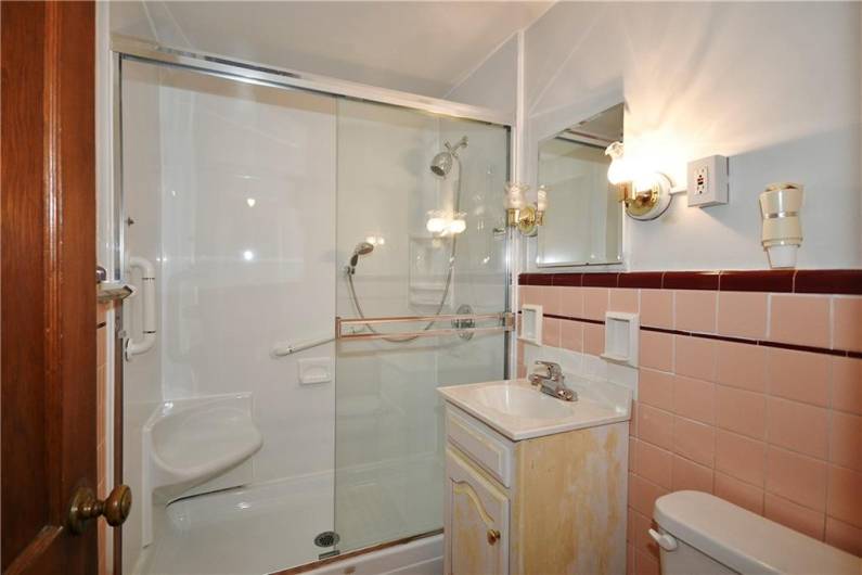 The main floor bath is conveniently situated between the two bedrooms. Shower is a walk in with neutral white.