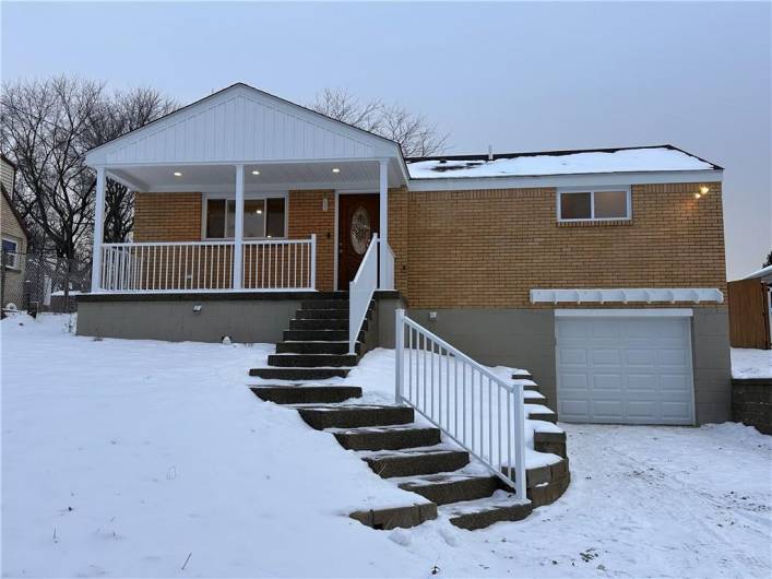 Brick ranch with new covered patio, stair case, door and garage door!