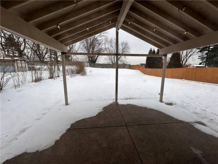 Covered back exposed aggregate patio leading out to the fenced back yard.  Patio lights and additional covered electrical light box wired to kitchen for light or fan if the new owner should desire.