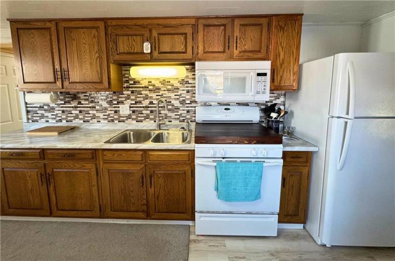 Main level kitchen, new flooring, countertops and backsplash.