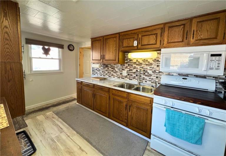 Main level kitchen, new flooring, countertops and backsplash.