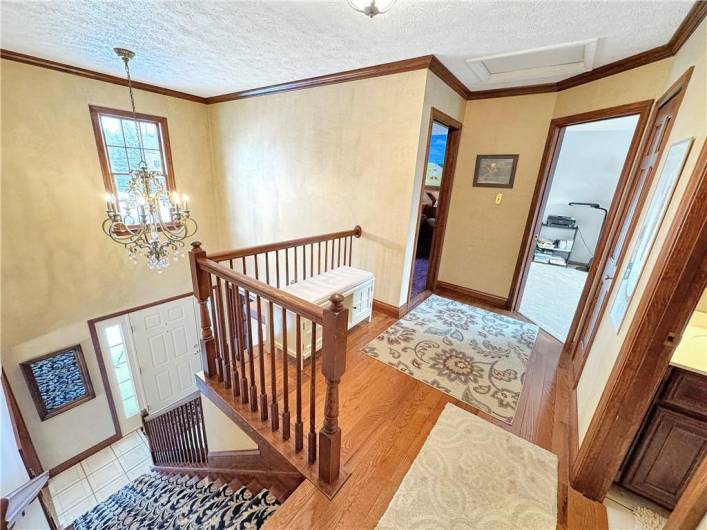 Second floor hallway with hardwood floors and crown moldings.