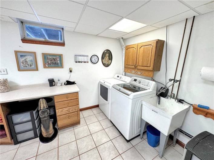 Finished laundry room has built-in cabinetry and a door to the back yard.