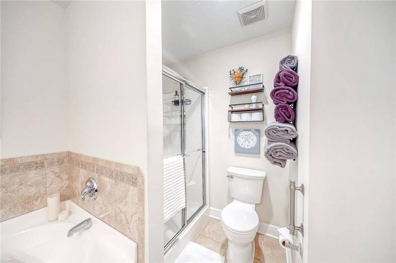 The primary en-suite bathroom boasts a tiles soaking tub, walk-in shower, and solid wood vanity.