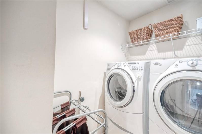 The main floor laundry is equipped with hanging storage and included applicances