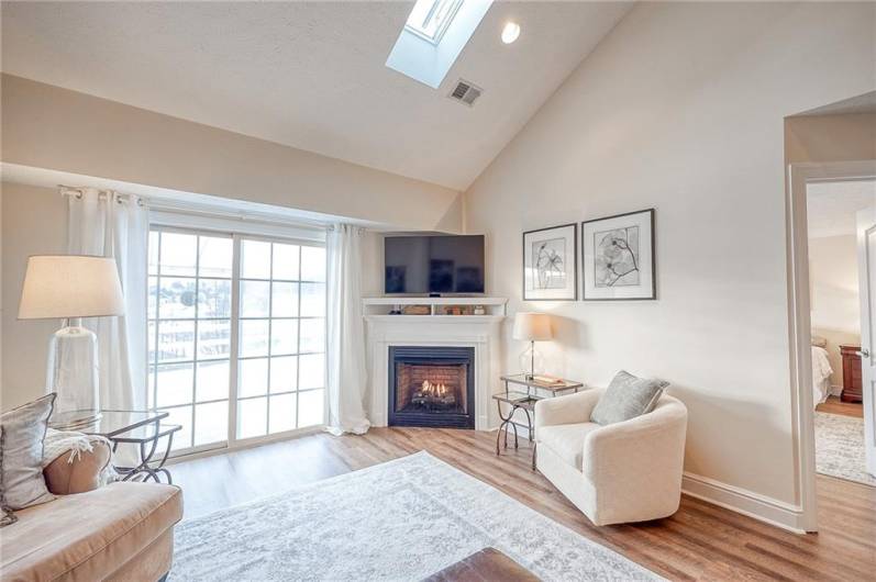 The emmense great room features brand new LVP flooring, cathedral ceilings, 2 skylights, a gas fireplace, and access to the rear patio