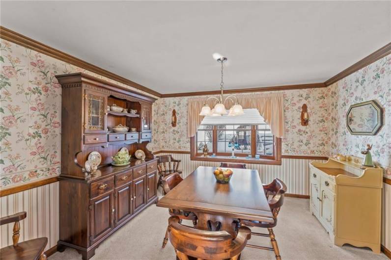 The elegant Dining Room features a new chandelier, crown moldings, chair rail and plush carpeting plus a beautiful bay window perfect for back yard views.