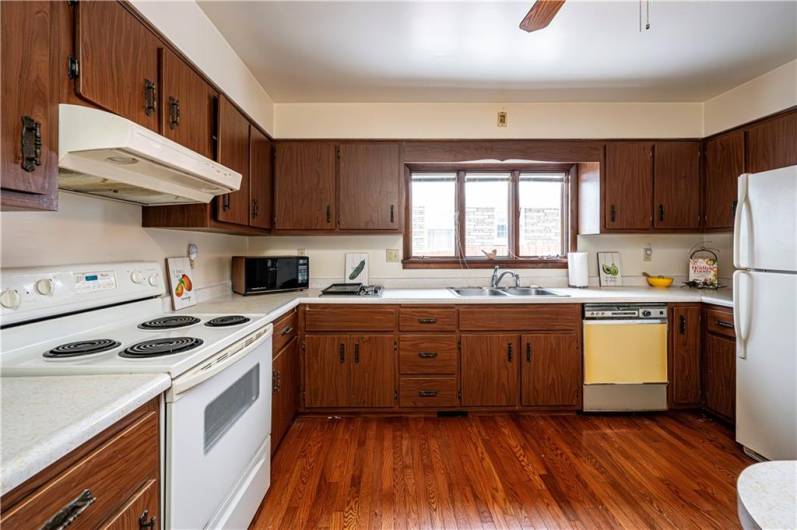 Lots of cabinets in this spacious kitchen with hardwood floors.