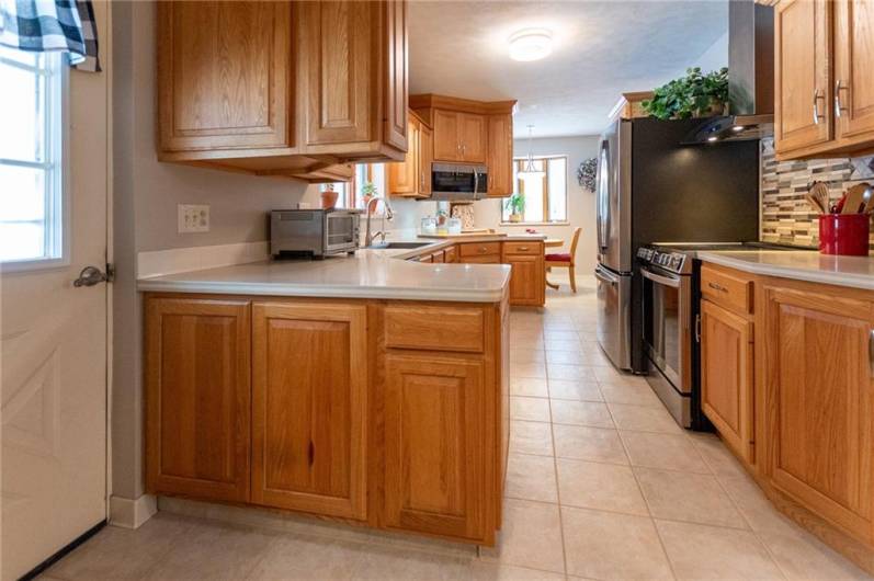 Well designed, natural oak cabinets open on both sides for convenience, Corian countertops, stainless steel appliances, Krous sink with accessories.