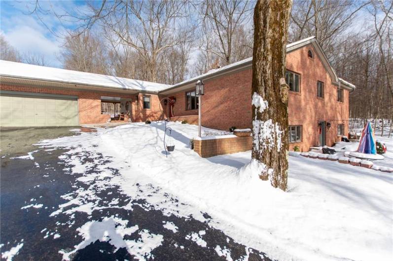 A welcoming entryway and ample parking space off to the side of the garage.