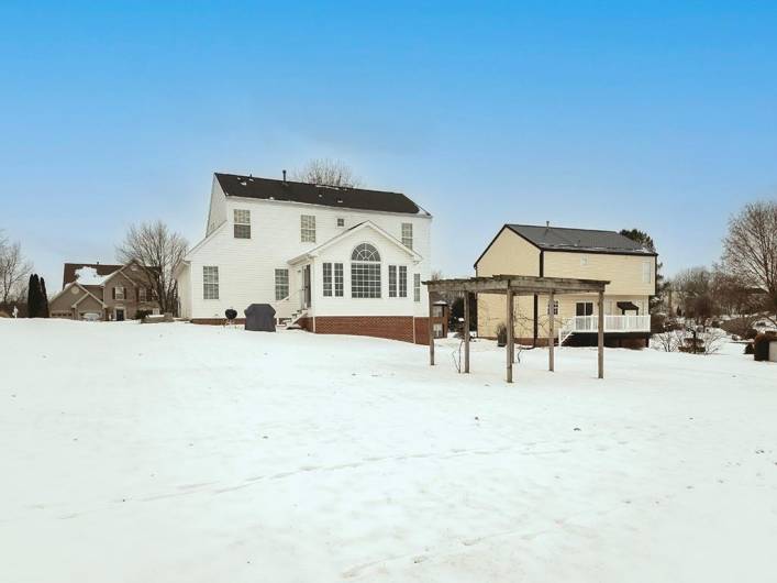 Expansive back yard features an established grapevine/harbor and raised garden beds can be found on the side of the house.