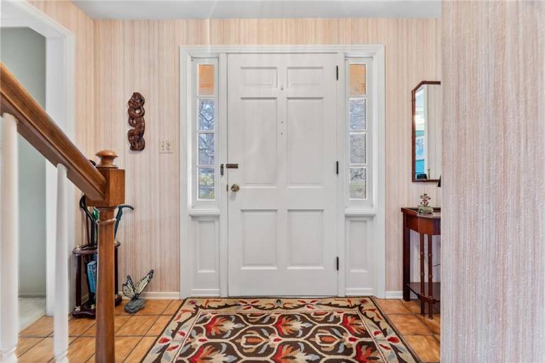 The spacious entryway with the formal living room to the left and half bath to the right