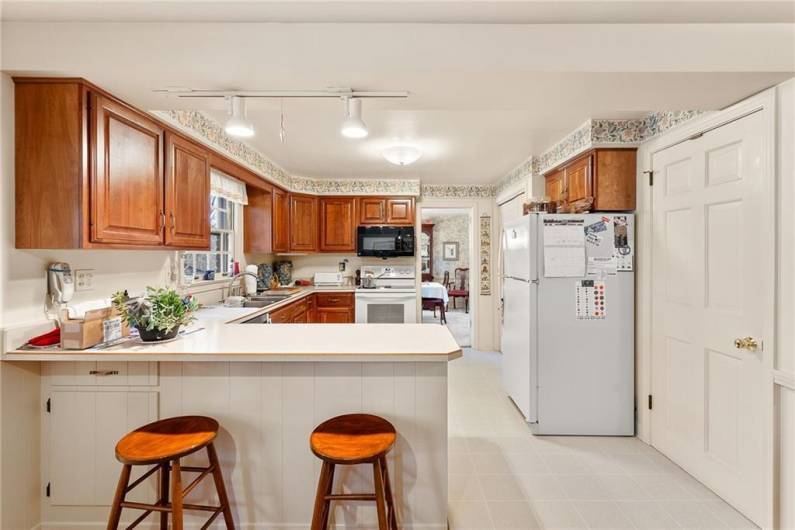 The kitchen with access to the lower level to the right and formal dining room straight ahead