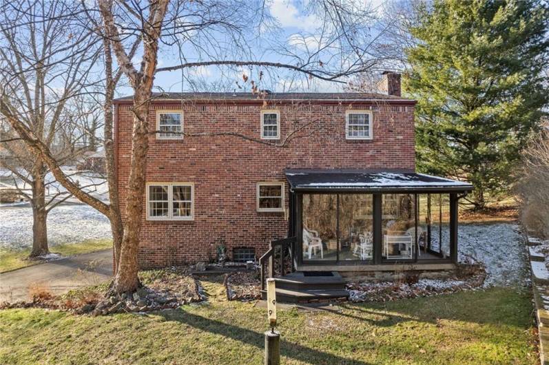 The back of this beautiful home with the sun room and a pond, landscaping/flowers will be beautiful in the spring.