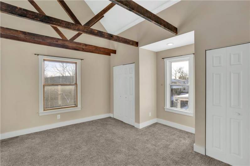 The primary bedroom features vaulted ceilings...